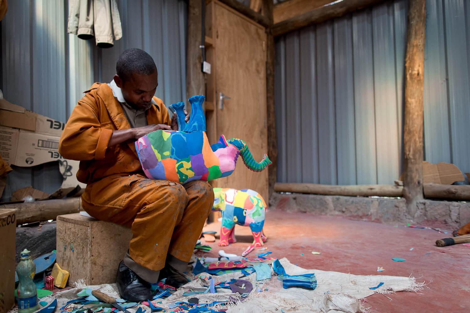 An Ocean Sole artisan finalizes an elephant made from recycled flip flops. © Jaymi Heimbuch