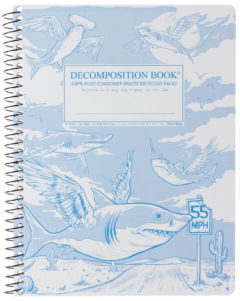 A spiral bound notebook with light blue flying sharks